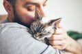 Close-up of cat and man. Portrait of a Devon Rex kitten and young beard guy. Royalty Free Stock Photo