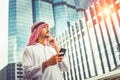 Handsome arab business man hold smartphone and looking to right side. Arab business man standing outside office