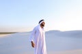 Handsome Arab sheik suffers from discomfort in back, standing in