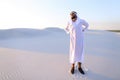 Handsome Arab sheik suffers from discomfort in back, standing in