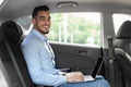 Handsome arabic entrepreneur sitting at auto, using laptop, mockup Royalty Free Stock Photo