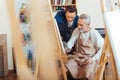 Handsome artist helping elderly man in painting