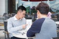 Handsome Asian business colleagues or college students work together using laptop, startup project meeting or teamwork brainstorm Royalty Free Stock Photo