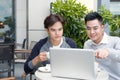 Handsome Asian business colleagues or college students work together using laptop, startup project meeting or teamwork brainstorm Royalty Free Stock Photo