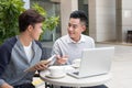 Handsome Asian business colleagues or college students work together using laptop, startup project meeting or teamwork brainstorm Royalty Free Stock Photo