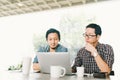 Handsome Asian business colleagues or college students work together using laptop, startup project meeting or teamwork brainstorm Royalty Free Stock Photo