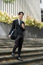 A handsome Asian businessman walking down the stairs in front of the building Royalty Free Stock Photo