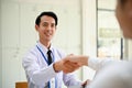 A handsome Asian businessman welcomes his guest by shaking hands, meeting in the office Royalty Free Stock Photo