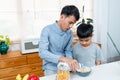 Handsome asian father scooping grains ready pour milk into cup It's breakfast in cup for my beloved son, Royalty Free Stock Photo