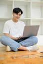 Handsome Asian male college student in library co-working space, using laptop Royalty Free Stock Photo