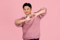 Handsome asian man with beard wearing pink sweater smiling in love doing heart symbol shape with hands. romantic concept Royalty Free Stock Photo