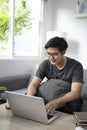 Handsome man browsing internet with computer laptop at home. Royalty Free Stock Photo