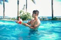 Handsome asian men having fun with water gun at swimming pool under sunlight Royalty Free Stock Photo