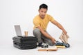 A handsome Asian man is packing his belongings into his travel luggage, isolated white background Royalty Free Stock Photo