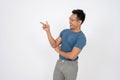 A handsome Asian man is pointing his finger aside at an empty space on an isolated white background Royalty Free Stock Photo