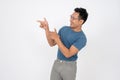 A handsome Asian man is pointing his finger aside at an empty space on an isolated white background Royalty Free Stock Photo