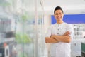 handsome asian man smiling with crossed hands near cell phone accessories display case Royalty Free Stock Photo