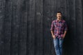 Handsome Asian man smiling while leaning against a wall outside Royalty Free Stock Photo