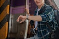 A handsome Asian man traveler is checking time on his wristwatch while getting off the train Royalty Free Stock Photo