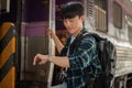 A handsome Asian man traveler is checking time on his wristwatch while getting off the train Royalty Free Stock Photo