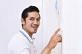 Handsome asian man turning off the light with wall switch Royalty Free Stock Photo