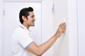 Handsome asian man turning off the light with wall switch Royalty Free Stock Photo