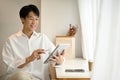 A handsome Asian man using his digital tablet while relaxing in a coffee shop Royalty Free Stock Photo