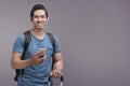 Handsome asian man using mobile phone while holding suitcase Royalty Free Stock Photo