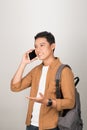 A handsome Asian student taking on cell phone isolated on white background Royalty Free Stock Photo