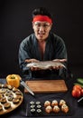 Handsome assian chef with fish on hands looking a the camera Royalty Free Stock Photo