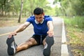 Handsome, athlete Asian man stretching his legs and feet on the street, warming up Royalty Free Stock Photo