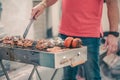 Handsome man preparing barbecue for friends.Hand of young man grilling some meat and vegetable. Royalty Free Stock Photo