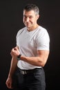 Handsome Athletic man in white blank t-shirt standing on black wall background Royalty Free Stock Photo