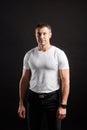 Handsome Athletic man in white blank t-shirt standing on black wall background Royalty Free Stock Photo