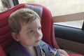 Handsome attentitive baby boy in child car seat