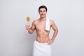 Handsome, attractive guy with bristle, stubble and towel on shoulder, presenting fetlock in arm, looking at camera, isolated on w Royalty Free Stock Photo