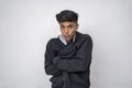 Handsome attractive indian man in black hoodie looking into the camera arms crossed standing against white background. winter Royalty Free Stock Photo