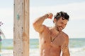 Handsome attractive smilling men showering in beach shower