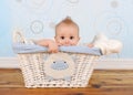 Handsome baby boy peeking out of wicker basket Royalty Free Stock Photo