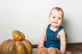 Handsome baby in denim overalls and pumpkin. Complementary feeding of children, first autumn of toddler, Halloween, food allergies Royalty Free Stock Photo