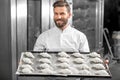 Handsome baker holding tray full of freshly baked croisants Royalty Free Stock Photo