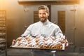 Handsome baker holding tray full of freshly baked croisants Royalty Free Stock Photo