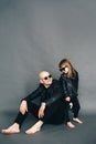 Handsome bald father with his little daughter in black sunglasses in biker clothes are posing in studio Royalty Free Stock Photo