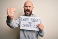 Handsome bald man with beard holding banner with funny positive message annoyed and frustrated shouting with anger, crazy and