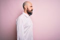 Handsome bald man with beard wearing elegant shirt over isolated pink background looking to side, relax profile pose with natural Royalty Free Stock Photo