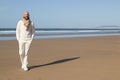 Handsome bald man in scarf strolling on beach