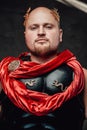 Bald roman with armour and cape poses in dark background