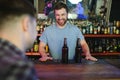 Handsome bar tender standing behind his counter in a pub Royalty Free Stock Photo