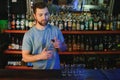 Handsome bar tender standing behind his counter in a pub Royalty Free Stock Photo
