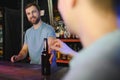 Handsome bar tender standing behind his counter in a pub Royalty Free Stock Photo